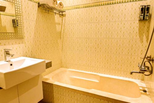 a bathroom with a sink and a bath tub at Trimrooms Buddha Varanasi in Varanasi