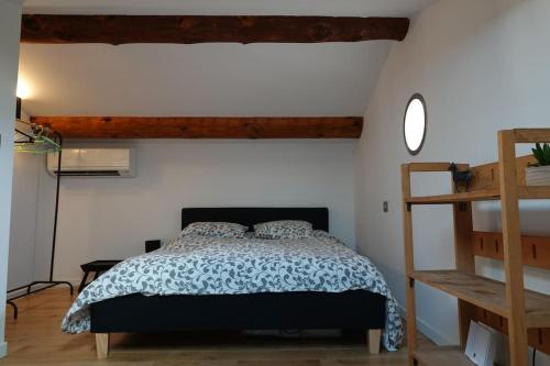 une chambre avec un lit et une échelle en bois dans l'établissement Coin de paradis en Provence, à Saint-Cannat