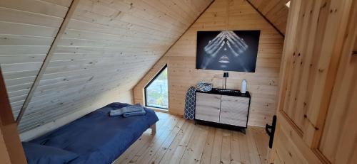 um quarto com uma cama num chalé de madeira em Świętokrzyskie Stodoły - Domek AJWO 