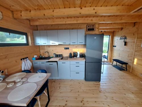 a kitchen with white cabinets and a table at Świętokrzyskie Stodoły - Domek AJWO in Psary