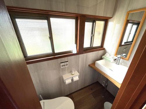 a bathroom with a sink and a toilet and windows at pine mountain - Vacation STAY 48815v in Goto