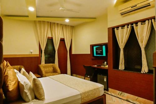 a hotel room with a bed and a desk at Trimrooms Buddha Varanasi in Varanasi