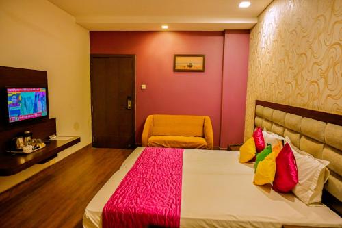 a hotel room with a bed and a chair at Trimrooms Buddha Varanasi in Varanasi