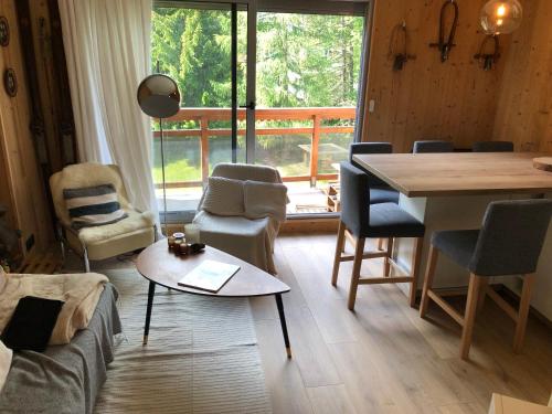 - un salon avec une table, des chaises et une grande fenêtre dans l'établissement Appartement 6 personnes aux 2 Alpes, au pied des pistes - Wi-fi, Parking gratuit, Terrasse vue sur jardin, à Les Deux Alpes