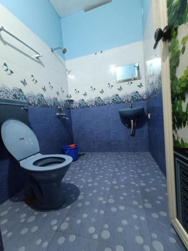 La salle de bains bleue est pourvue de toilettes et d'un lavabo. dans l'établissement Bamboo garden, à Varkala
