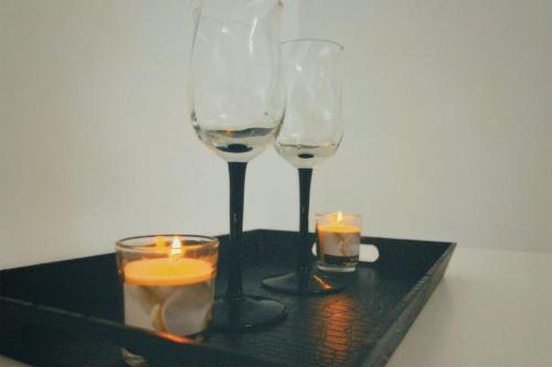 two wine glasses and candles on a black tray at Pop’s Apartment in Lupeni
