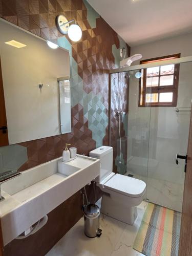 uma casa de banho com um lavatório, um WC e um chuveiro em Chalé Três - Casa de temporada em Tiradentes em Tiradentes