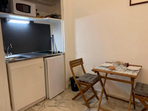 une petite cuisine avec une table et un micro-ondes dans l'établissement Cannes center AC wifi 200 m sea behind Martinez Hotel, à Cannes