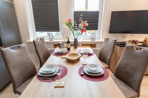 a dining room with a table with chairs and a television at Richter Altstadtappartements in Goslar