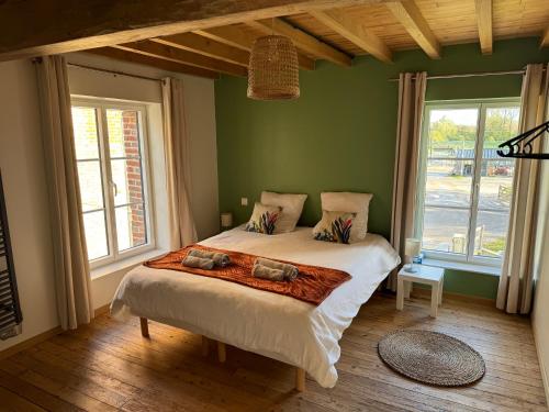 uma cama num quarto com paredes verdes e janelas em Le Gite du Moulin de la Pisciculture de Monchel sur Canche em Conchy-sur-Canche