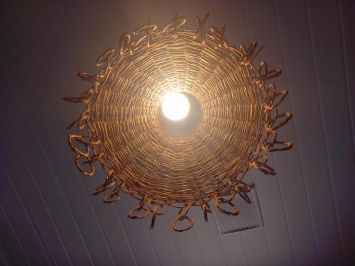 a wicker chandelier hanging from a ceiling at Chalé Palhano Beach in São Miguel dos Milagres