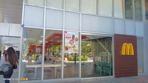 a mcdonalds restaurant with a mcdonalds sign in a window at Mactan Newtown Beach Condo in Mactan