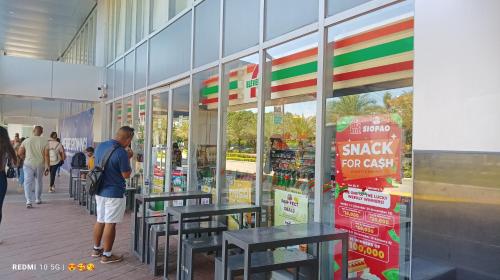a man looking in the window of a grocery store at Mactan Newtown Beach Condo in Mactan