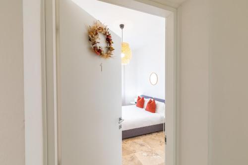 a bedroom with a bed and a door with a wreath at L'Acqua e la Pietra in Rapolano Terme