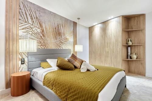 a bedroom with a large bed with a yellow blanket at Apartment Batignolle Montmartre by Studio prestige in Paris