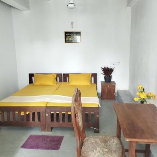 a bedroom with a bed and a table and a chair at Glance Beach Ahangama in Ahangama