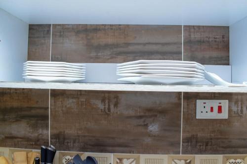 a stack of white plates on a shelf at Millan Homes in Mombasa