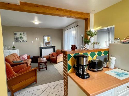a kitchen and a living room with a counter top at Gîte Margot in Vacqueriette