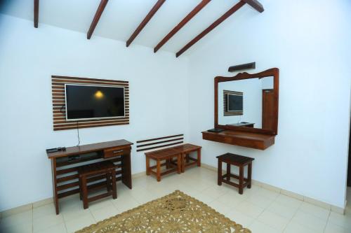 a living room with a television and a mirror at Royal Retreat, Sigiriya 5 mins to Sigiriya Rock in Sigiriya