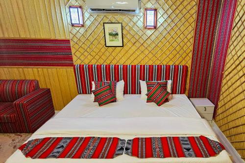 a small bedroom with a bed and a chair at Al Salam Desert Camp Bidiya in Bidiyah