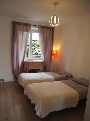 - 3 lits dans une chambre avec fenêtre dans l'établissement Le Cocon, à Millau