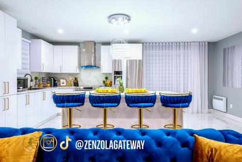 a living room with a blue couch and a kitchen at Zenzola's gateway Near Downtown in Longueuil