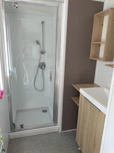 une salle de bain avec une douche avec une porte vitrée dans l'établissement Mobil home 6 à 8 personnes camping le bois dormant, à Saint-Jean-de-Monts