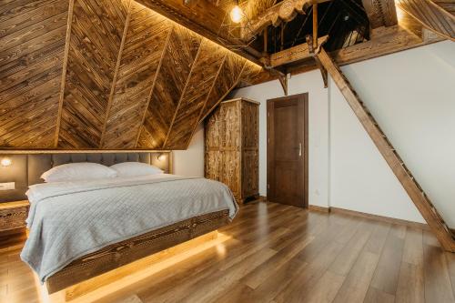 Schlafzimmer mit einem großen Bett und Holzdecken in der Unterkunft Domek na Wilczniku in Zakopane