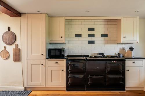 a kitchen with a black stove top oven at Yew Tree: Historic Georgian Farmhouse, Ellonby in Ellonby