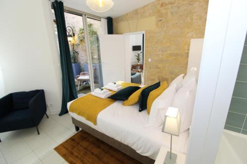 - une chambre avec un lit doté d'oreillers jaunes et blancs dans l'établissement Appartement Sarlovèze - Stay in Sarlat, à Sarlat-la-Canéda