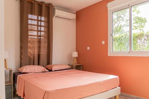 een slaapkamer met een bed en een raam bij Villa Swany in Petit-Bourg