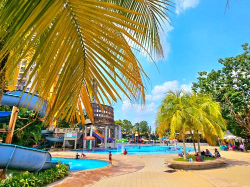 a pool at a water park with palm trees at Melaka BY LG Water Themepark & Resort By GGM in Melaka