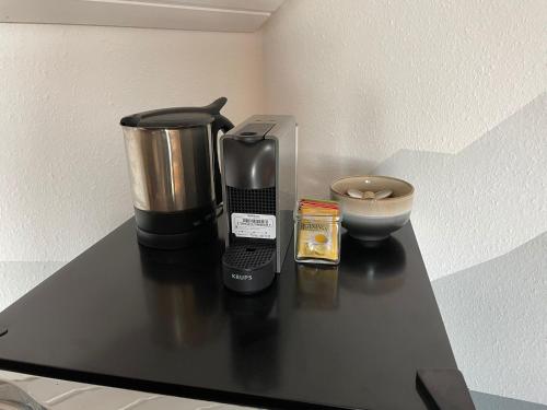 een koffiezetapparaat op een zwarte toonbank met een kom bij Herzliches Zimmer im Zürcher Oberland in Wald