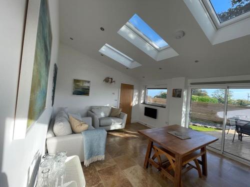 a living room with a couch and a table at Tranquil, secluded, rural cottage for two in Beaumaris
