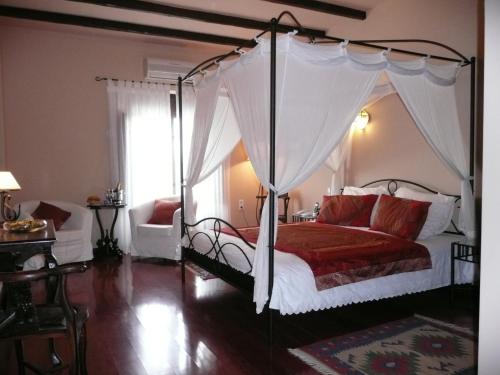 um quarto com uma cama de dossel e um edredão vermelho em A Dream in Beauty and Tranquility em Almogía