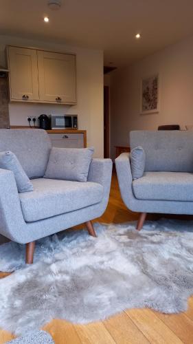 una sala de estar con 2 sofás y una alfombra en Keistle Cottage en Eyre