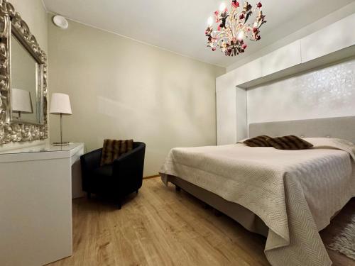 a bedroom with a bed and a chair and a mirror at FlatsinRoi Apartments in Rovaniemi