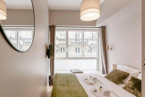 um quarto com uma grande janela e uma cama com uma banheira em Modern 2 bedrooms near Louvre em Paris