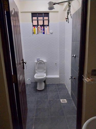 un piccolo bagno con servizi igienici e finestra di Nova suite a Eldoret