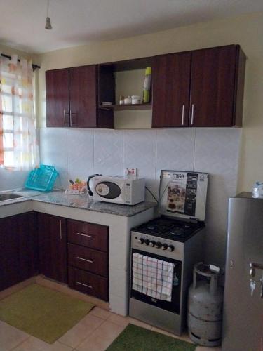 een keuken met een fornuis en een magnetron bij Nova suite in Eldoret