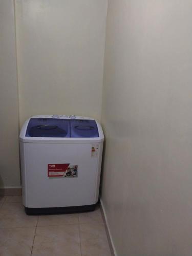 een kleine koelkast in een hoek van een kamer bij Nova suite in Eldoret