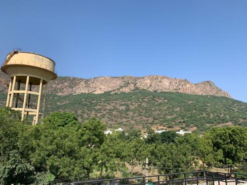 a water tower with a mountain in the background at Ashraya home stay in Pushkar valley in Ajmer