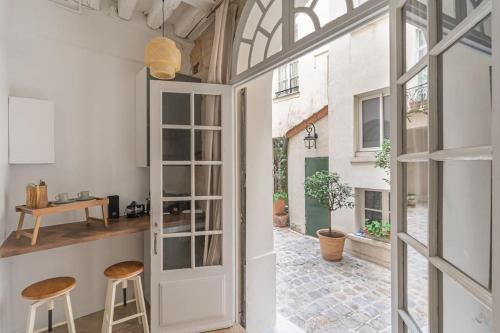 Cette chambre dispose d'une fenêtre et d'une cuisine avec tabourets. dans l'établissement Luxe - dream Location - for 2 pp, à Paris
