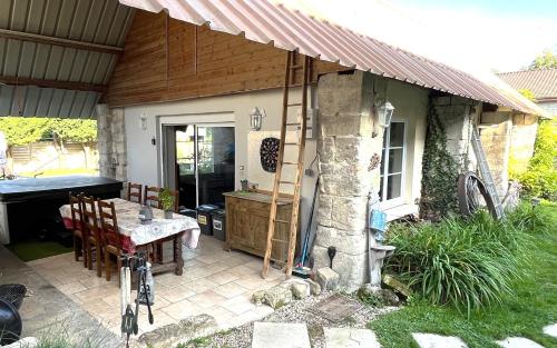 um pátio com uma mesa, um lavatório e uma casa em Relais de Poste des Templiers em Jouaignes