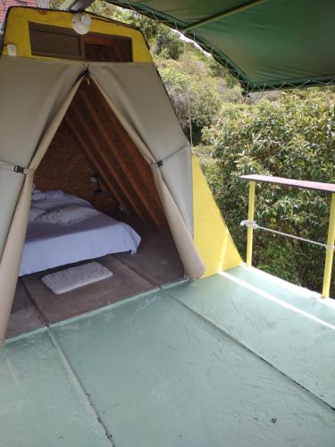 a green and yellow tent with a bed in it at Hotel Kira in Jericó