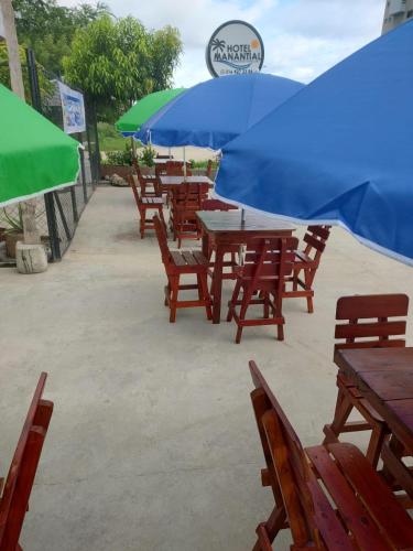 a group of tables and chairs with umbrellas at HOTEL MANANTIAL 1 in Playa Dormida