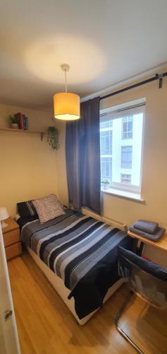 een slaapkamer met een bed voor een raam bij Private Room&Bath near the Square Mile in Londen