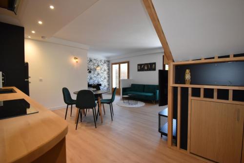 une cuisine et un salon avec une table et des chaises dans l'établissement Le Black Bulle, au Bourget-du-Lac