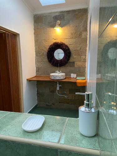 een badkamer met een wastafel en een spiegel op een aanrecht bij Emirishoi Cottages and Garden Bistro in Narok