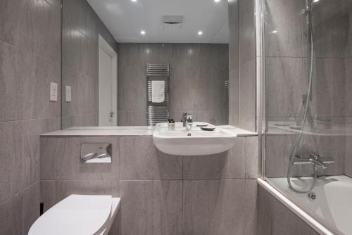ein Bad mit einem Waschbecken und einer Dusche in der Unterkunft The Lockton - Portobello Road in London